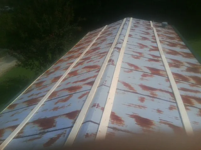Rusted metal roof panels with new wood purlins before replacement — Storm Damage Roof Repair in Mack by Roofing Brothers