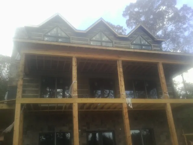 Dormers and porch framing on a large log home under construction in Mack