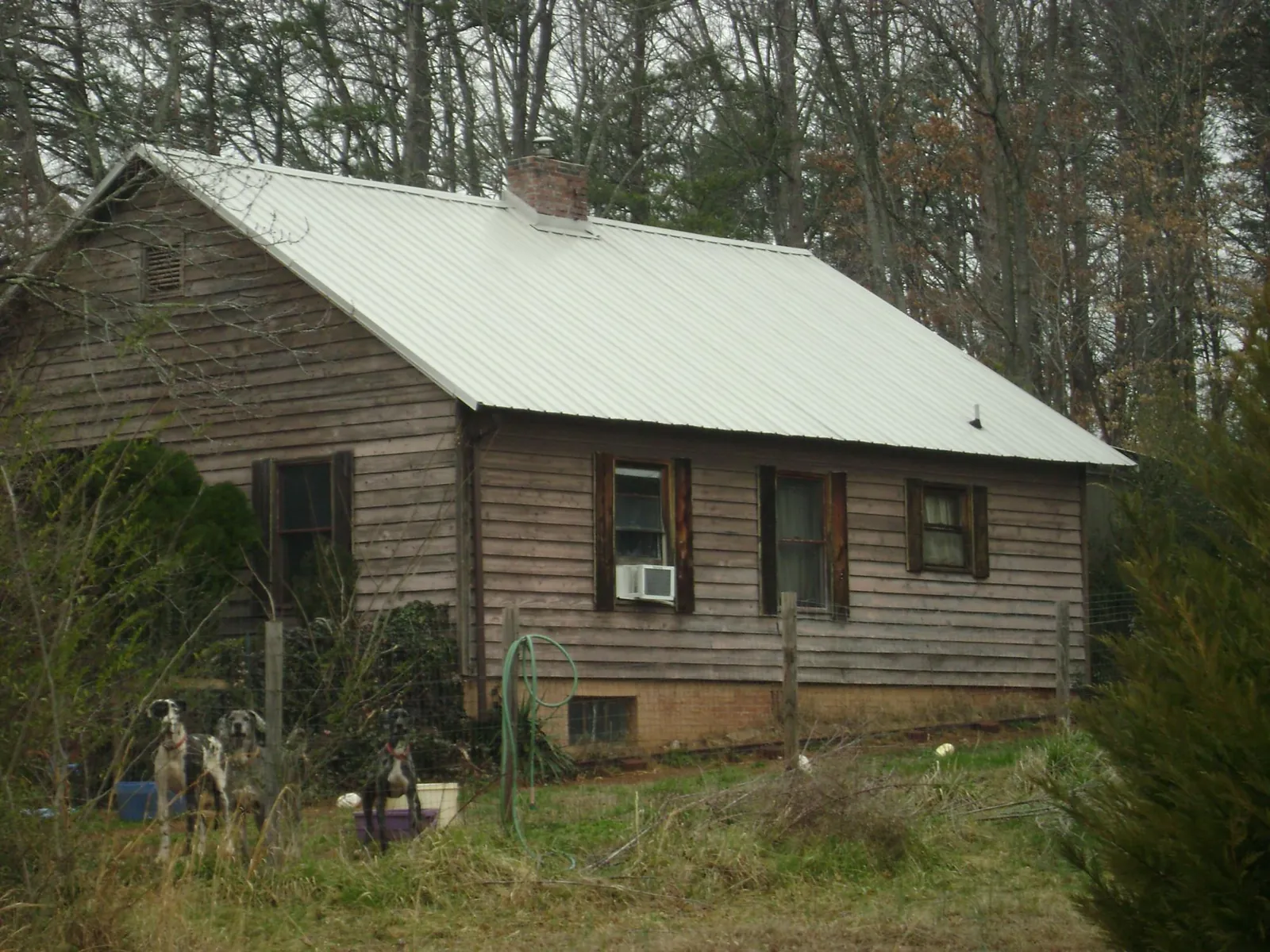 White metal roof on an old wood sided farmhouse, from a Metal Roof Installation job in Mack